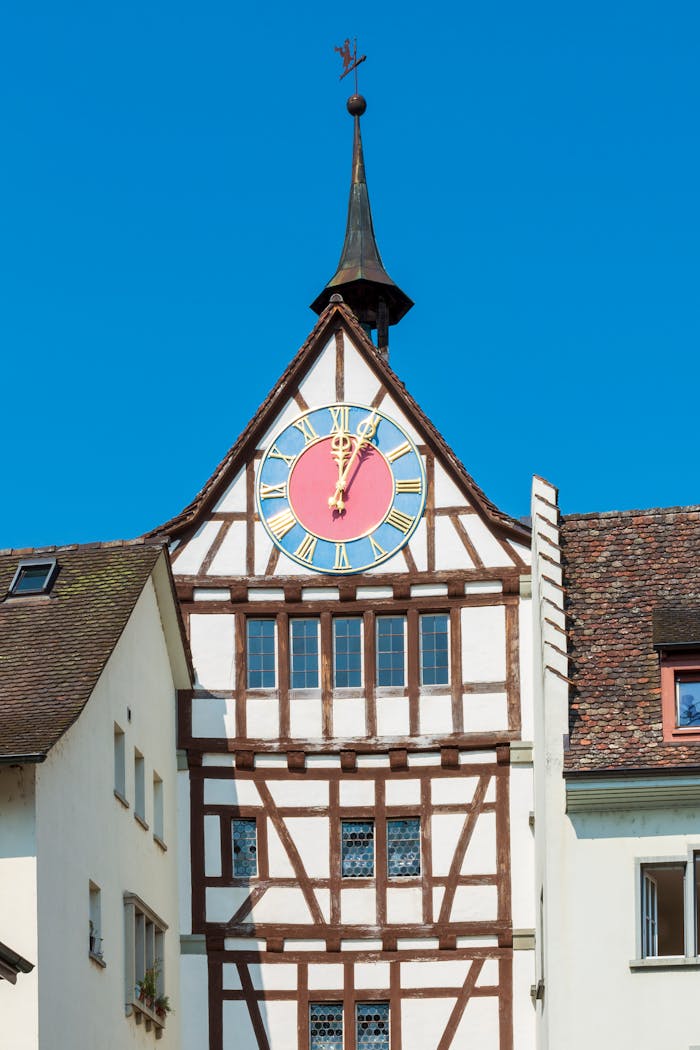 Beautiful half-timbered clock tower in Stein am Rhein, Switzerland against a clear blue sky.